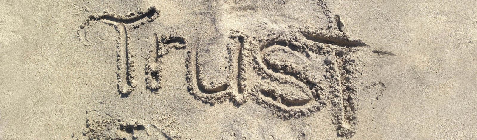 word trust in sand